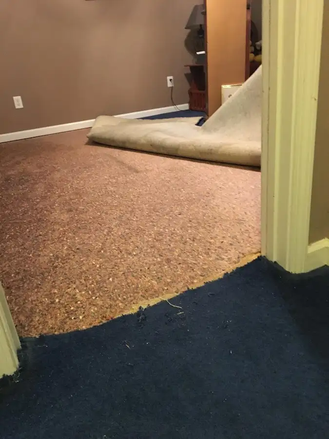 Carpet pad removal revealing water damage during Water Mitigation Services in Suamico